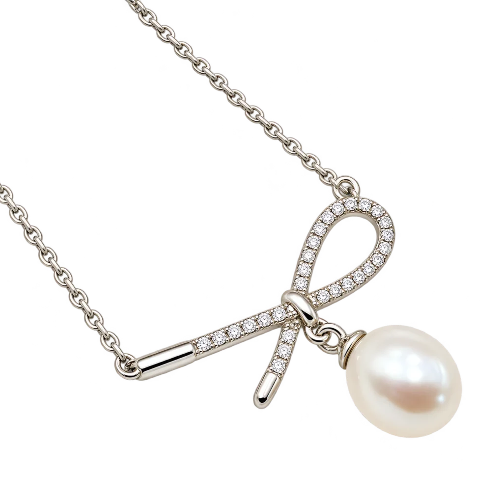Pavé silver ribbon bow necklace with a teardrop freshwater pearl drop on a silver chain.